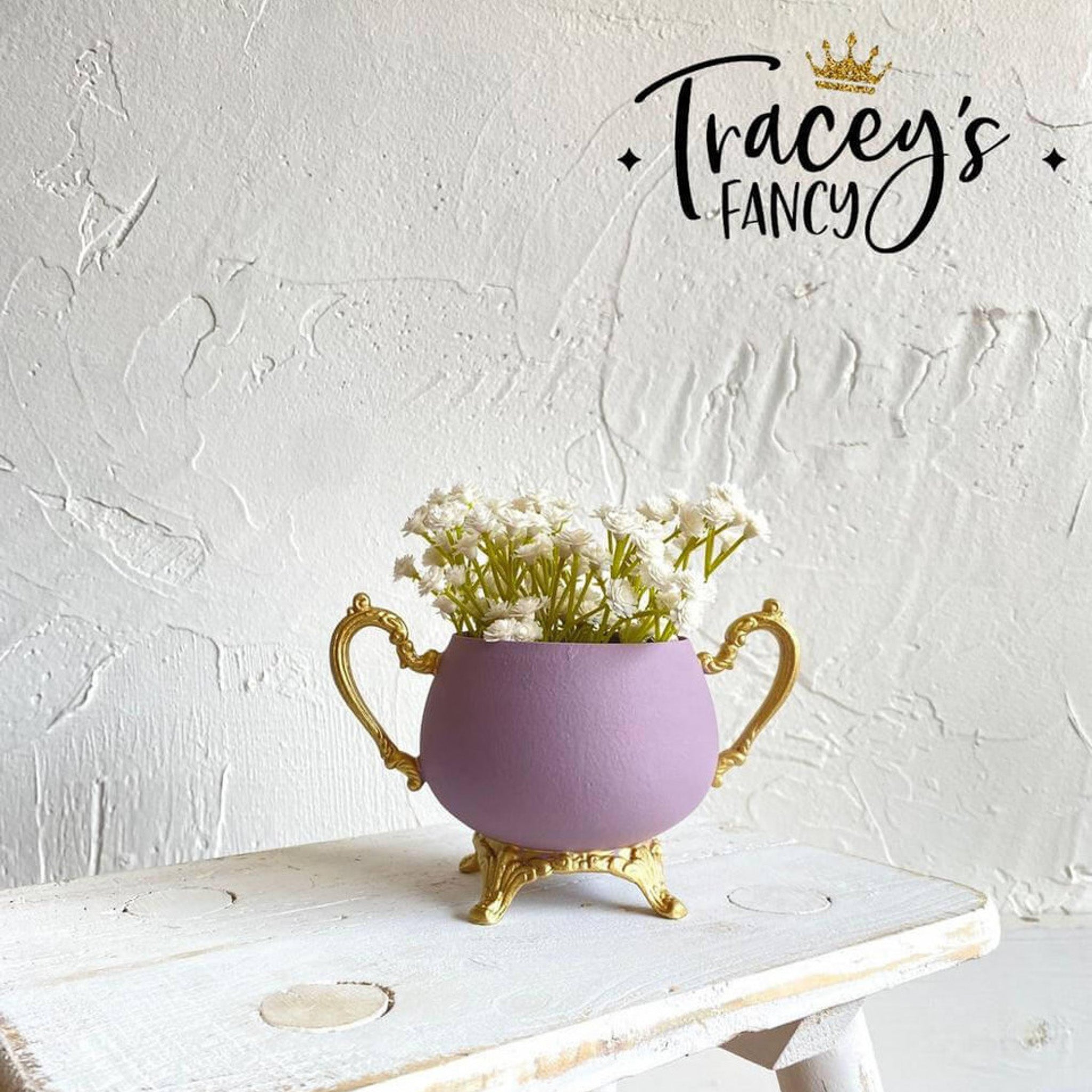 A ceramic vase refurbished by Tracey's Fancy is painted in Dixie Belle's Secret Path chalk mineral paint and has gold-painted legs and handleshandle.