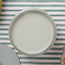 Jar of light green paint on  striped tablecloth