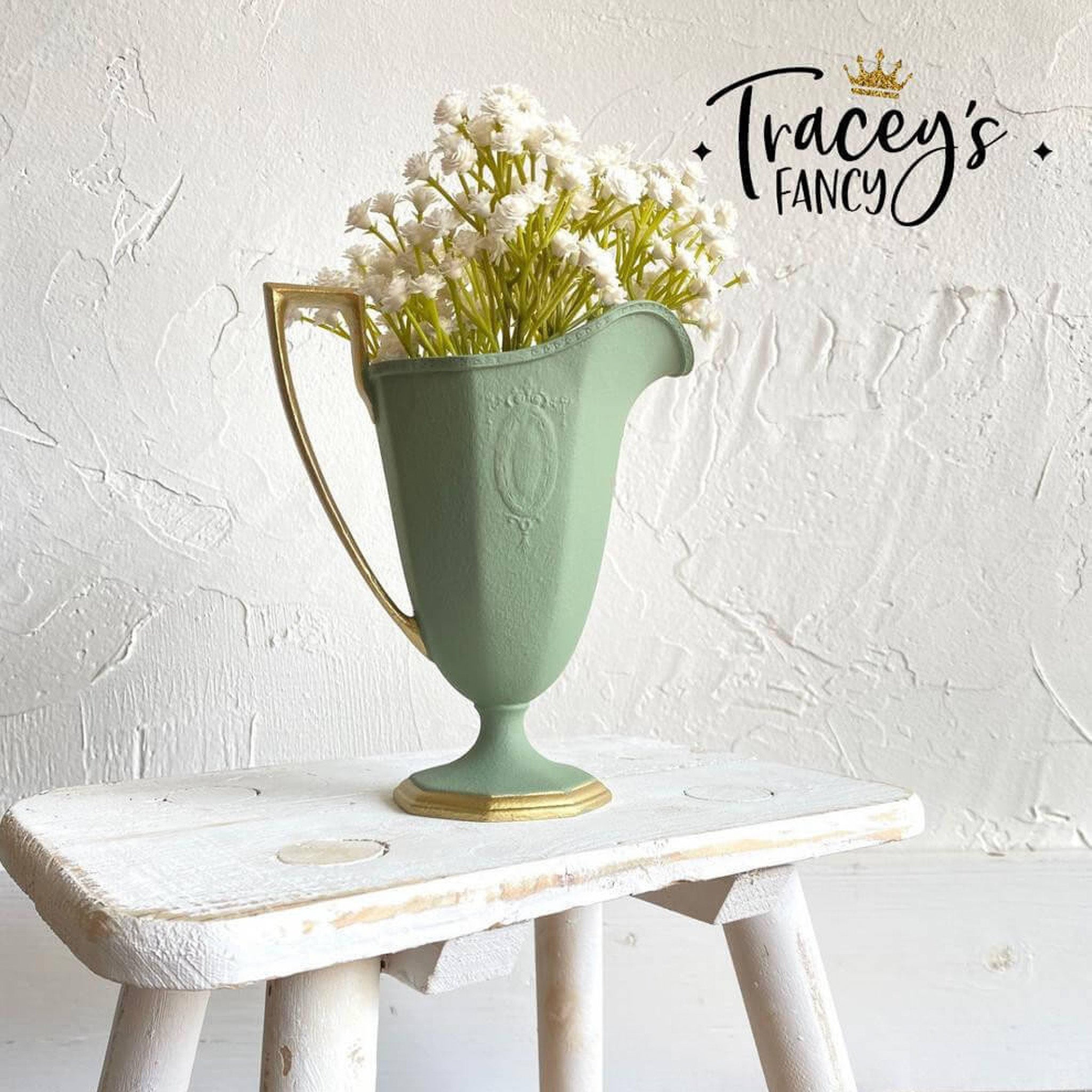 A ceramic water pitcher refurbished by Tracey's Fancy is painted in Dixie Belle's Weeping Willow Chalk Mineral Paint and has a gold-painted handle and base border.