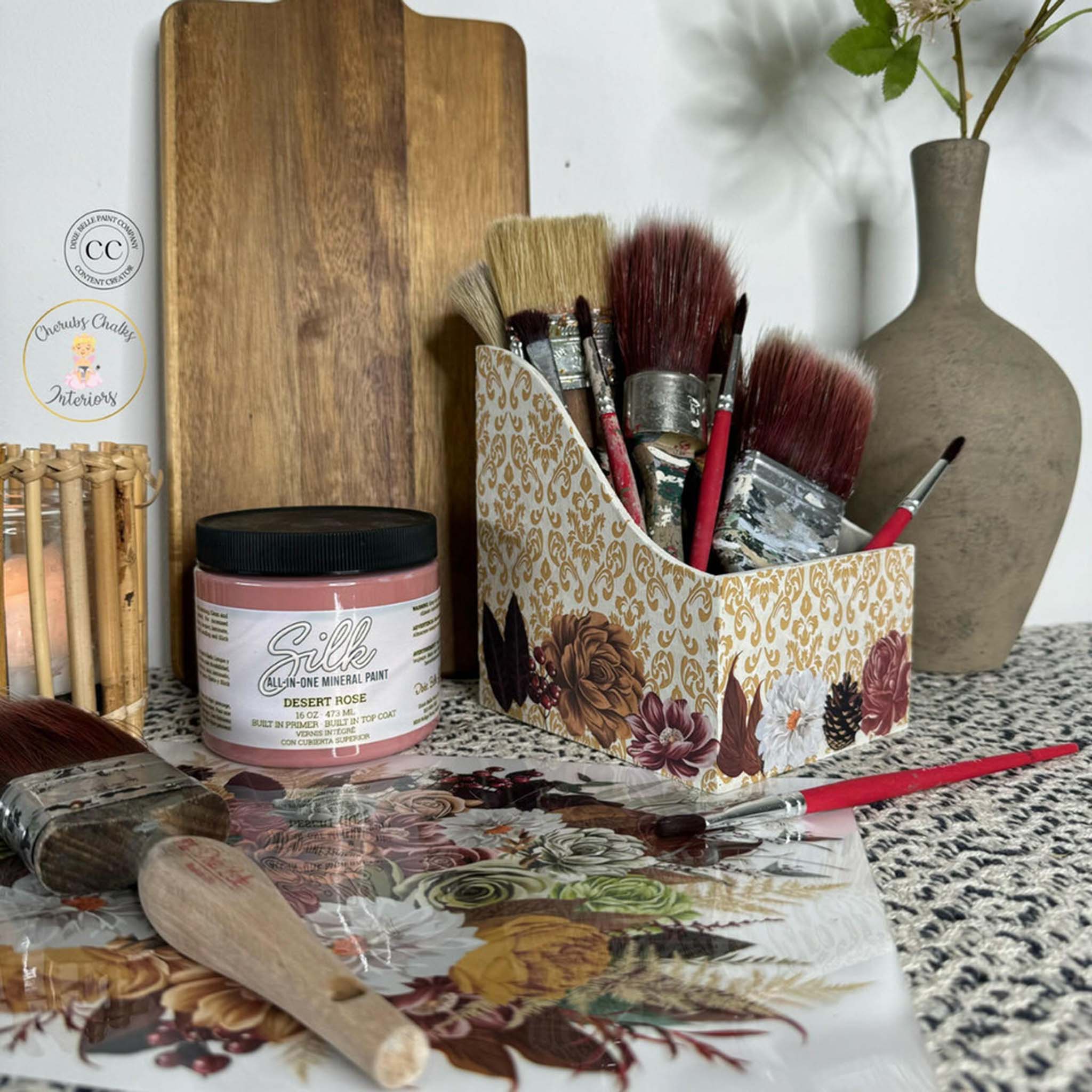 A craft desk with paint and paint brushes lie on a sheet of Belles & Whistles' Earthy Bouquet small transfer.