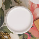 Round white paint on a floral-patterned surface