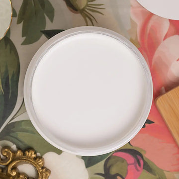Round white paint on a floral-patterned surface