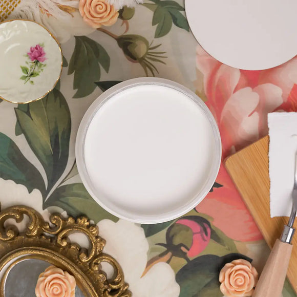 White round object on a decorative table with floral patterns and a gold frame.