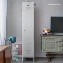 Tall white locker in a room with a television and decorative items.