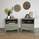 Two green nightstands with decorative items against a white wall.
