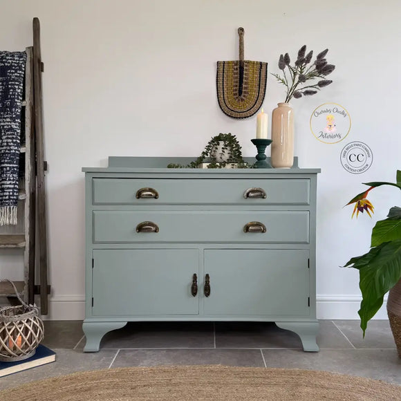 Light green dresser with decorative items in a room setting