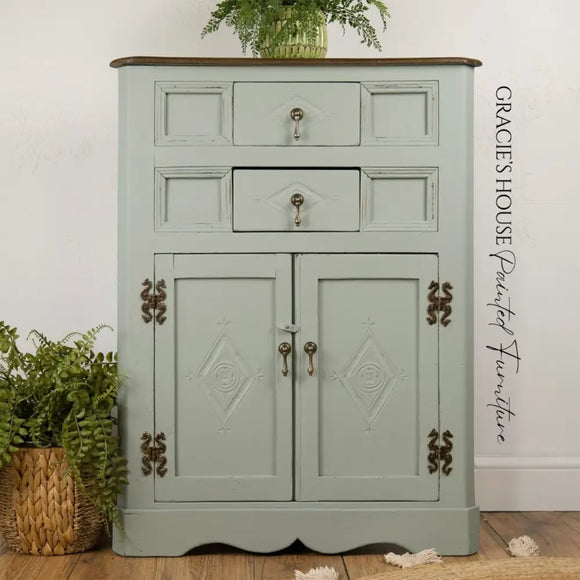 Vintage-style cabinet with decorative elements on a wooden floor, featuring the brand 'Gracie's House'.