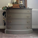 Gray dresser with gold handles in a room setting