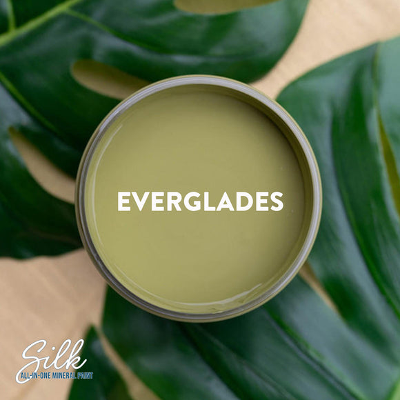 An arial view of an open container of Dixie Belle Paint Company's Everglades Silk All-In-One Mineral Paint is shown with white text reading Everglades.