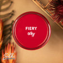 An arial view of an open container of Dixie Belle Paint Company's Fiery Sky Silk All-In-One Mineral Paint is shown with white text reading Fiery Sky.