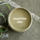 An arial view of an open container of Dixie Belle Paint Company's Hampton Olive Silk All-In-One Mineral Paint is shown with white text reading Hampton Olive.