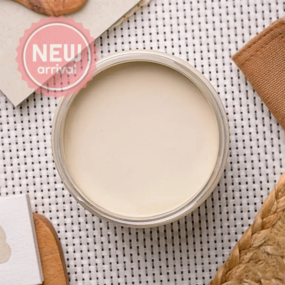 An arial view of an open container of Dixie Belle Paint Company's Ecru Chalk Mineral Paint is on a white lattice table with other items.