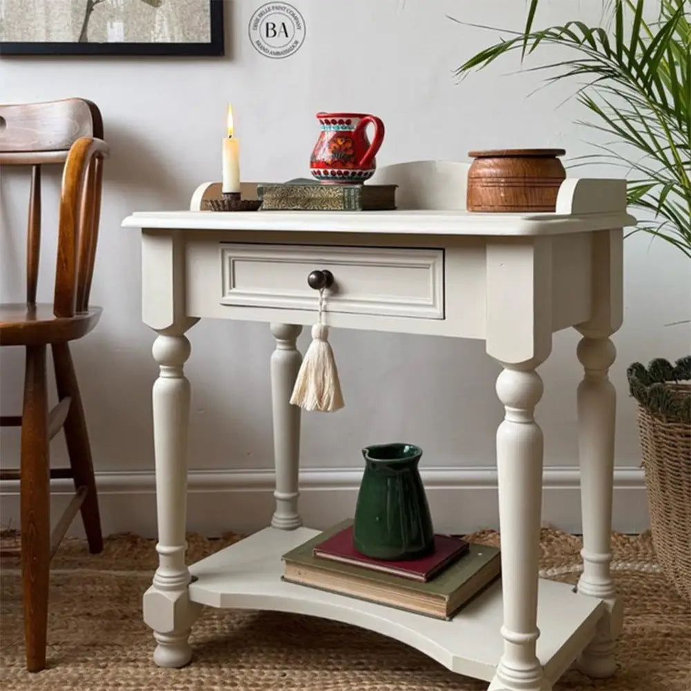 A small vintage side table with a drawer and bottom shelf features Dixie Belle's Ecru Chalk Mineral Paint.