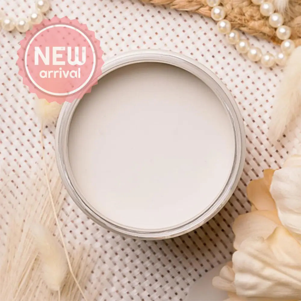 An arial view of an open container of Dixie Belle Paint Company's Gardenia Chalk Mineral Paint is on a white lattice table with other items.