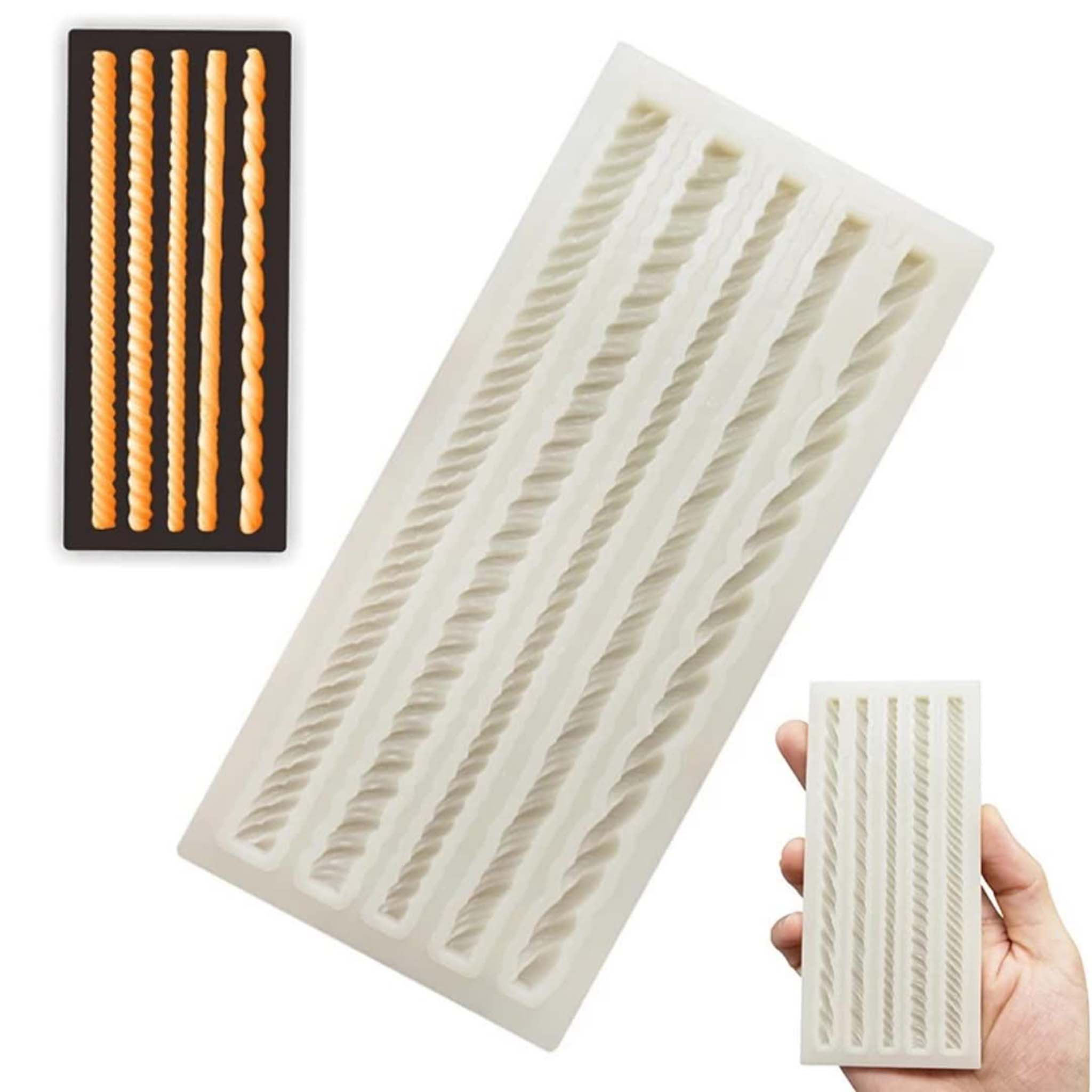 A light beige silicone mold and orange colored castings shown against black of 5 mini rope borders are on a white grey background. A hand is shown holding the silicone mold in the bottom right corner.