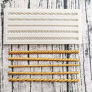 A light beige silicone mold and gold colored castings of 5 mini rope borders are against a grey striped material background.