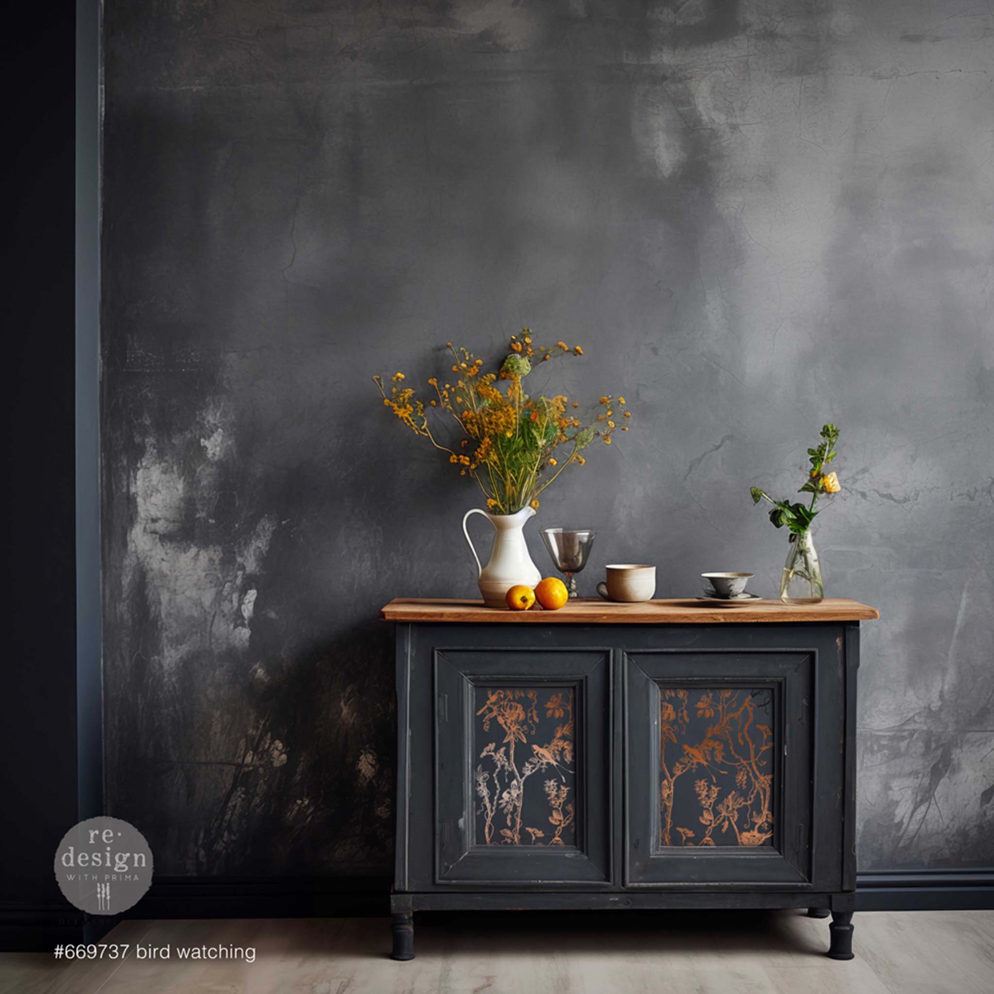 A vintage bar cabinet is painted black with a natural wood top and features ReDesign with Prima's copper foil rub-on transfer Bird Watching by Kacha.