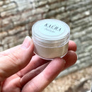 A small 0.5 oz container of a sample of KACHA Azucar furniture paint is being held.