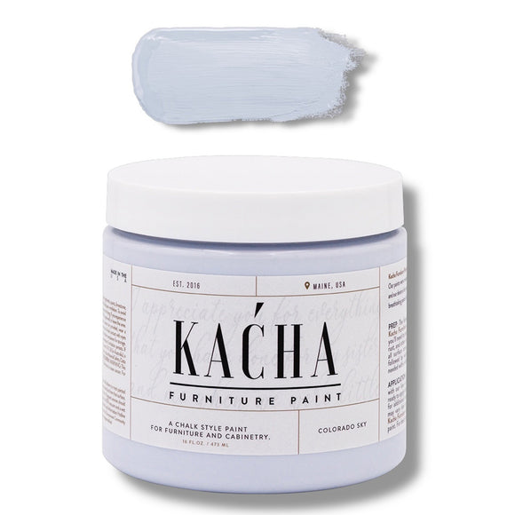 A 16 oz container and swatch sample of Kacha Furniture Paint in the color Colorado Sky (soft pale blue) is against a white background.