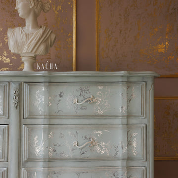 A close-up of a vintage large dresser refurbished by Kacha features Kacha South Beach paint with silver details.