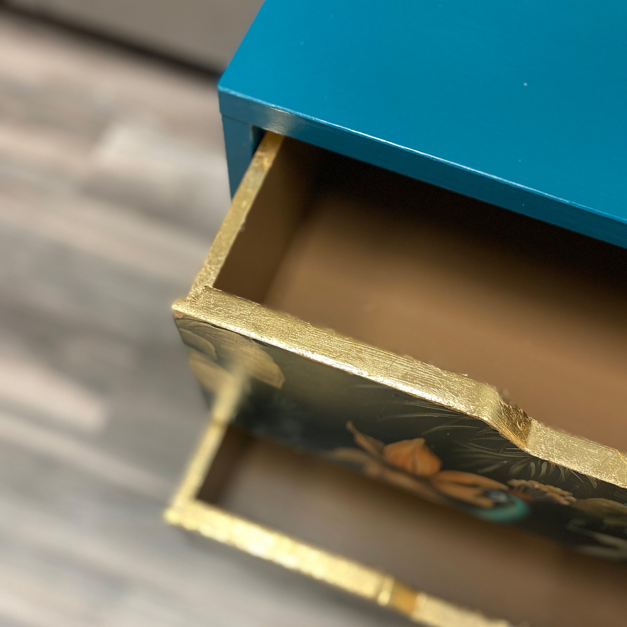 A close-up of 2 open furniture drawers feature ReDesign with Prima's Kacha Gold Leaf Gilding on the edges of the drawers.