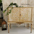 A vintage bar cabinet refurbished by Secret Garden is painted light beige and features ReDesign with Prima's Kacha Orleans rub on transfer on its 2 doors.