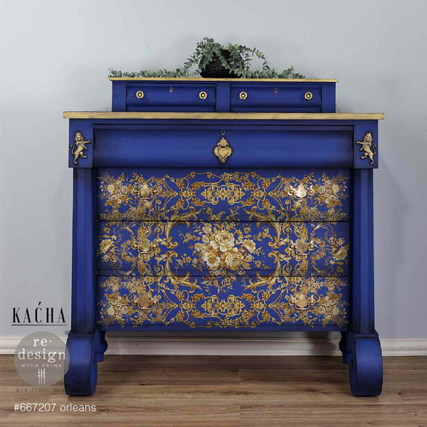A vintage dresser refurbished by Kacha is painted royal blue with gold accents and features ReDesign with Prima's Kacha Orleans transfer on the drawers.