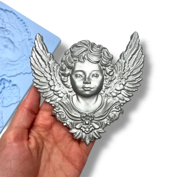Decorative angel figurine held in a hand with a blue textured background