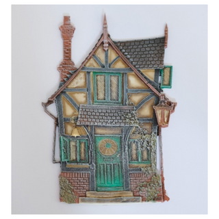 Colorful painted casting of a Victorian style fairy house.