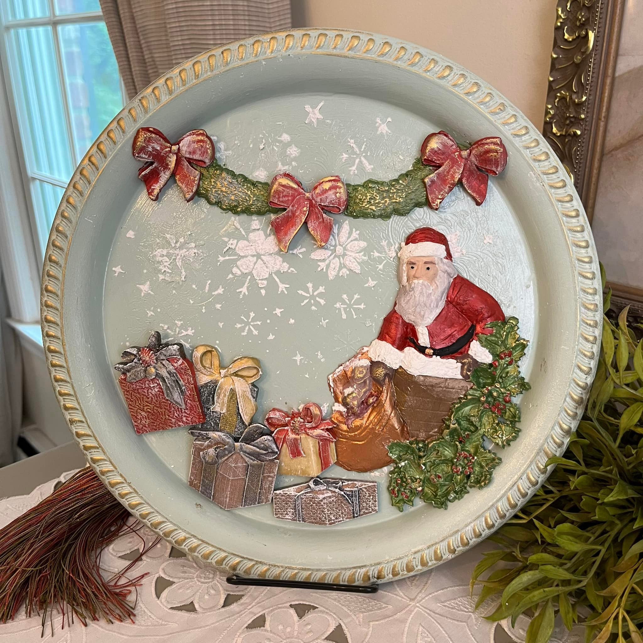 A ceramic plate craft features colorful castings of LaBlanche's Christmas Gifts silicone mold on it along with Santa and garland castings.