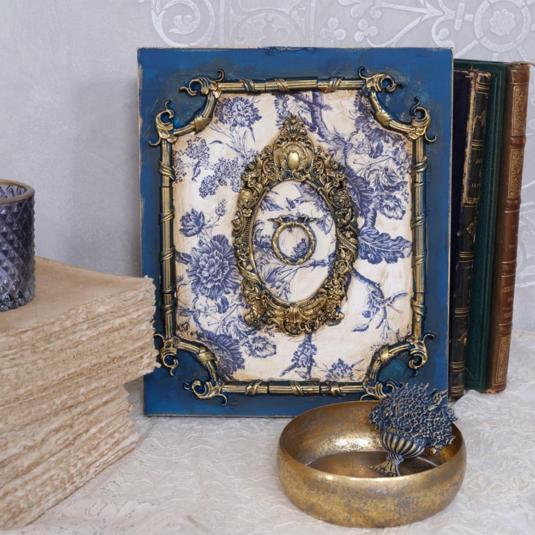 A wood craft that is painted blue with a blue toile design features antique silver colored castings of LaBlanche's Frame Lydia silicone mold.