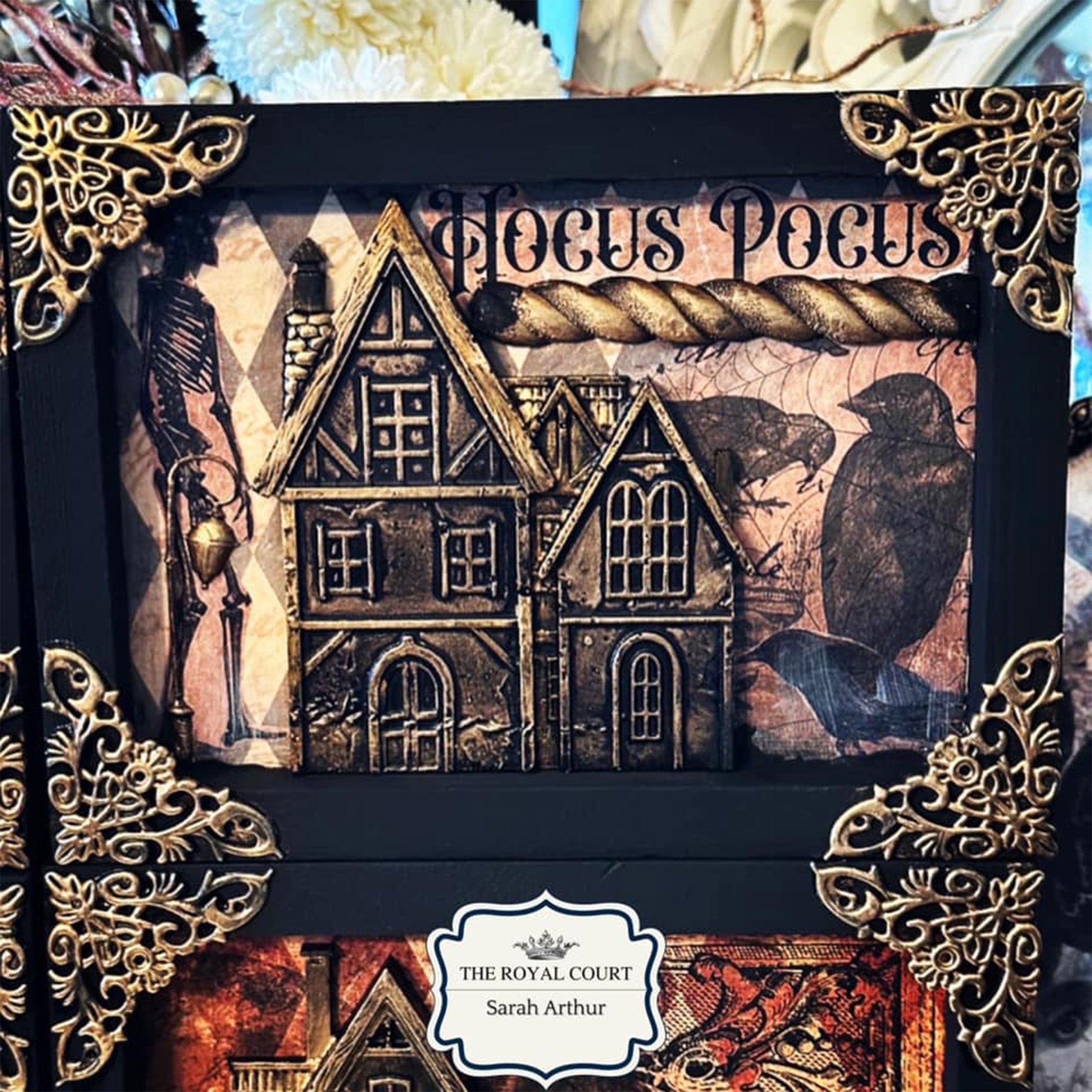 A close-up of a 4 picture frame collage that is painted black features a gold colored casting from LaBlanche's Houses 2 silicone mold.