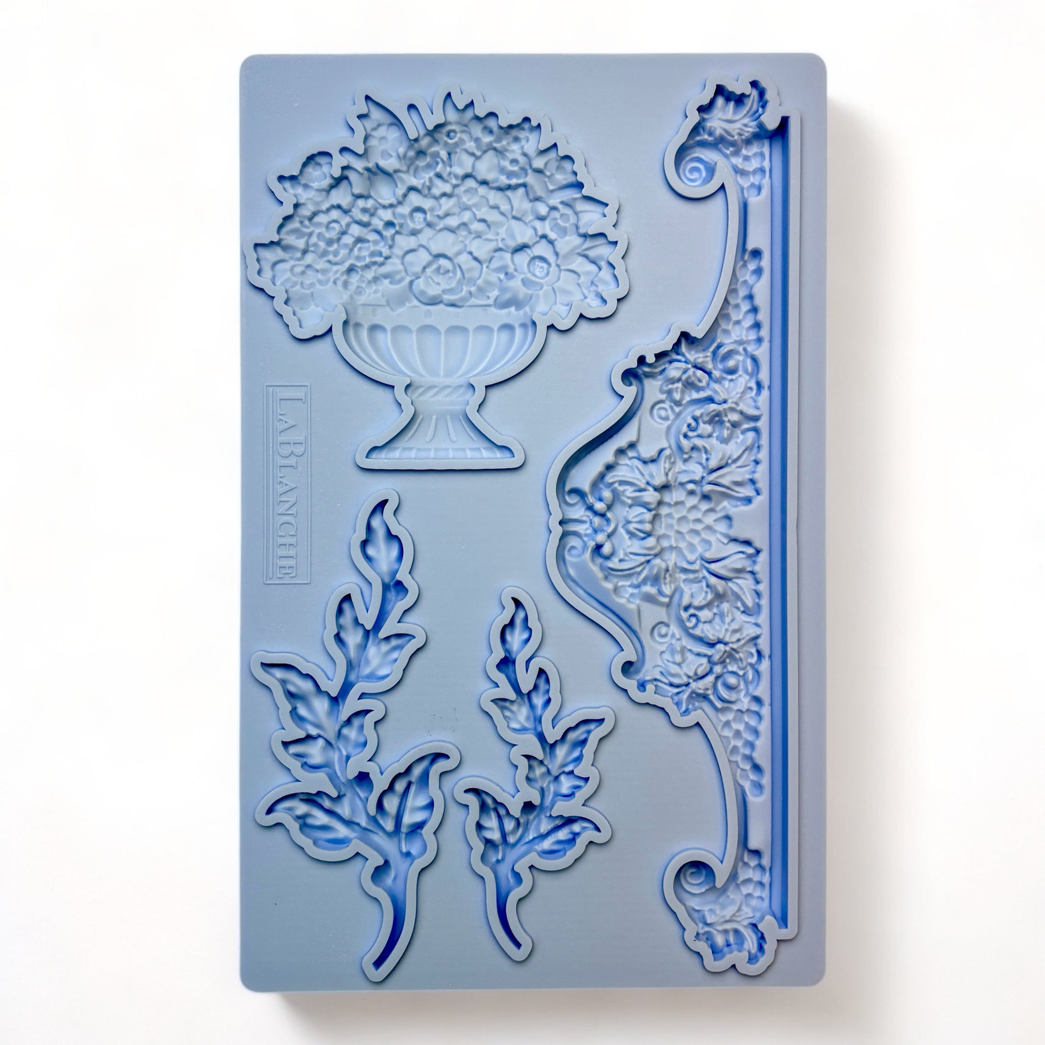 A blue silicone mold of a planter pot with flowers, 2 vines, and a center accent piece is against a white background.