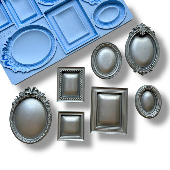 A blue silicone mold and silver colored castings featuring 7 small square, oval, and rectangular vintage photo frames are against a white background.