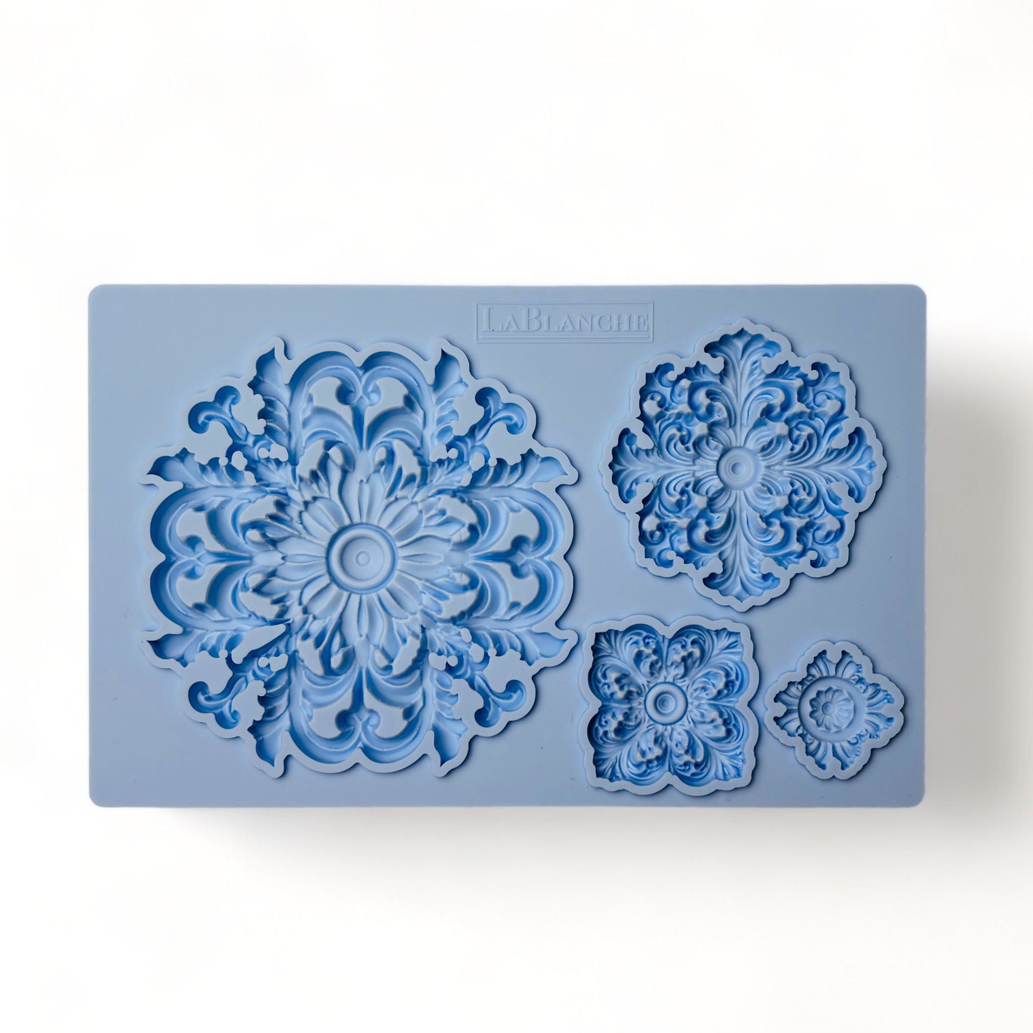 A blue silicone mold that features 4 varying size round ornate medallions is against a white background.