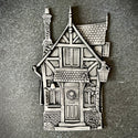 Silver colored casting of a small fairy house.