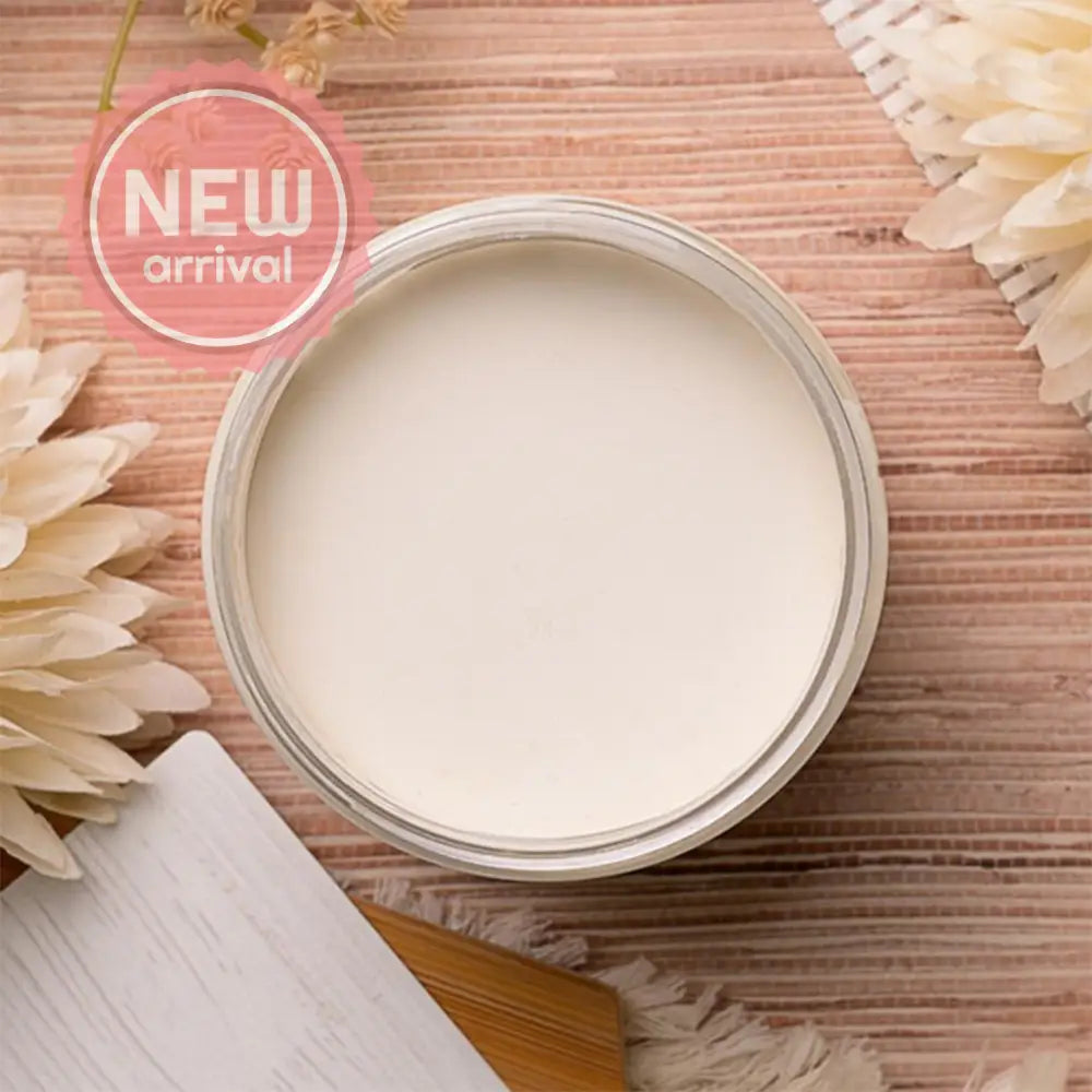 An arial view of an open container of Dixie Belle Paint Company's Magnolia Chalk Mineral Paint is on a table with other items.