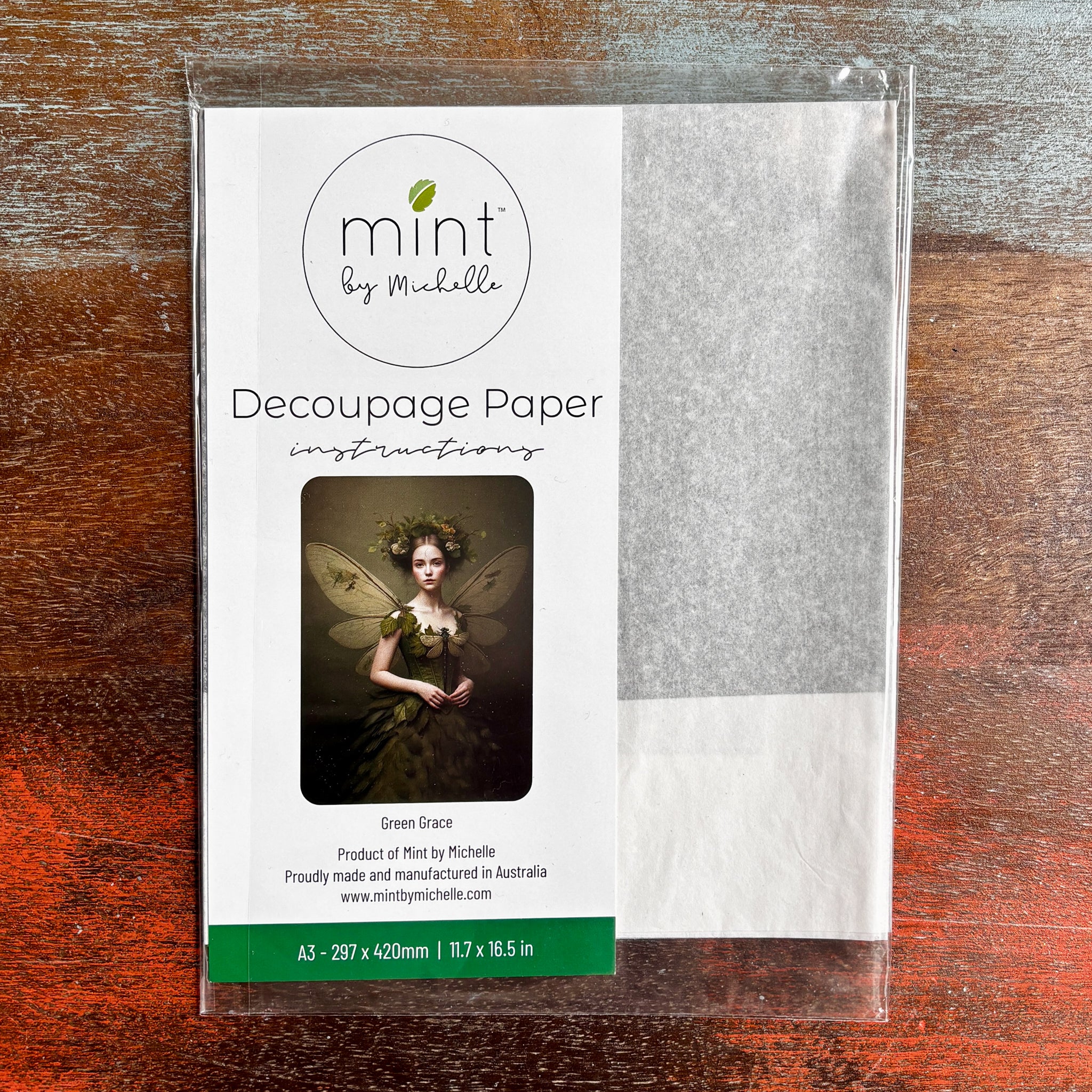 A package of Mint by Michelle’s Green Grace A3 Decoupage Paper is against a dark wood background. 
