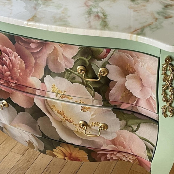 Floral-patterned drawer with gold handles on a decorative cabinet.