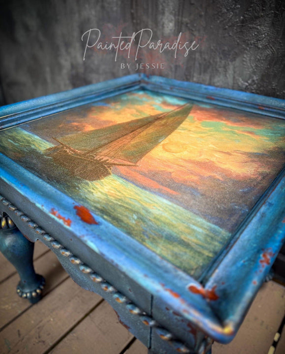 Decorative table with a painted sailboat design on a textured surface
