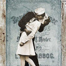 Close-up of a rice paper design of a vintage newspaper with a blue flyer featuring  a dashing sailor sweeping a white-dressed damsel off her feet for a passionate kiss.