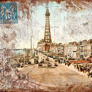 Close-up of a rice paper of a vintage sepia colored postcard featuring a quaint city street with an iron tower in the distance.