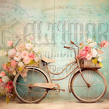 Close-up of a rice paper that features a Victorian bicycle adorned with pink and white roses sits against a French scrip backdrop. 