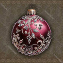 Decorative red Christmas ball ornament with intricate silver designs on a textured brown background.