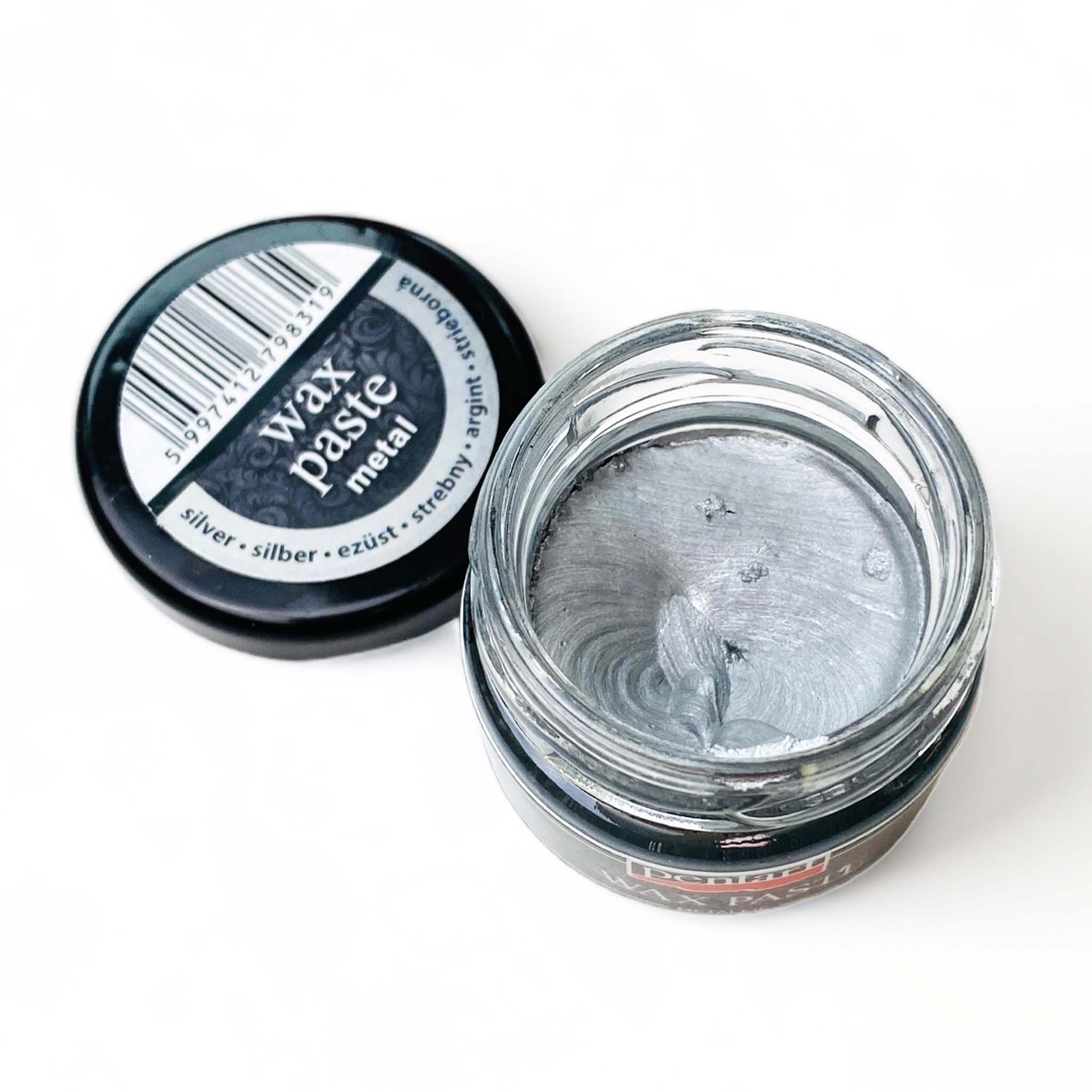 An open jar of a 0.68 ounce jar of metallic silver wax paste by Pentart is against a white background.