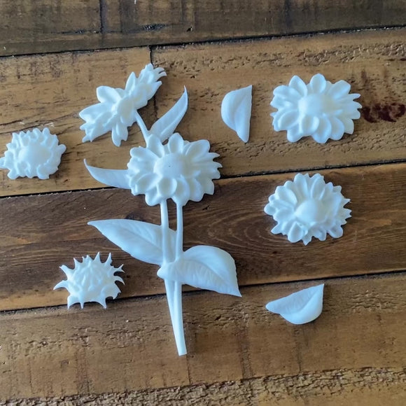 A 15 second video shows a close-up of white resin castings made from LaBlanche's Gerbera silicone mold against a dark wood background.