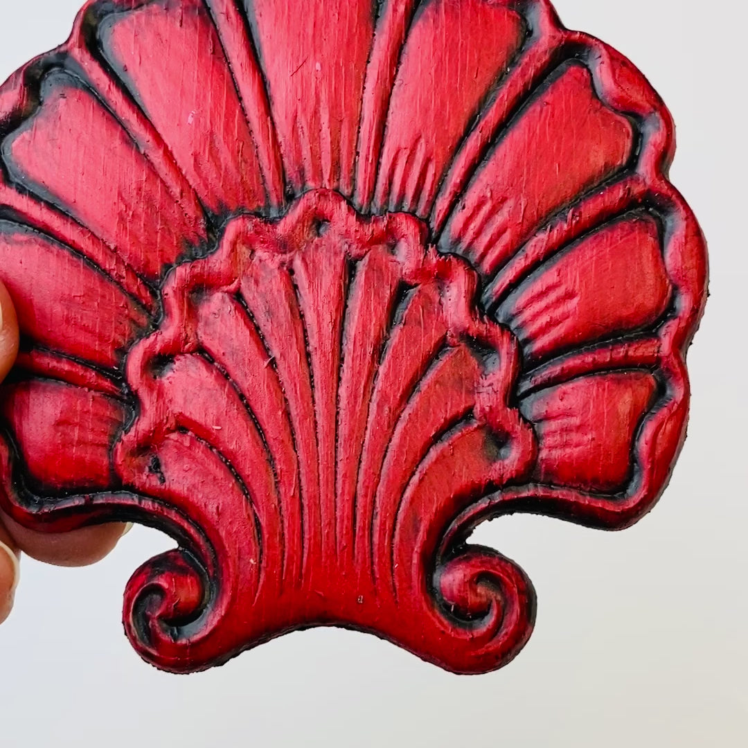 A 7 second video is shown holding a red shell shaped flower silicone mold casting that has been detailed with Dixie Belle's Black Glaze.