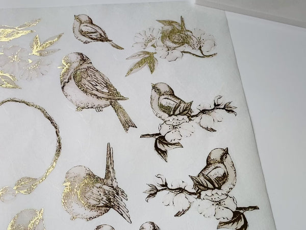 A 13 second video shows a hand lifting Decoupage Queen's Gilded Birds A4 rice paper and a ceramic tile with the rice paper on it to show the gilded bird designs.