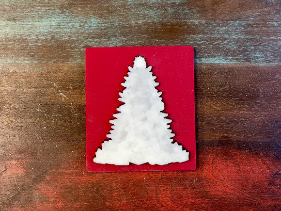 A 15 second video of Zuri Design's Bohemian Christmas Tree silicone mold and silver colored casting are against a wood background. A hand is shown holding the tree casting.