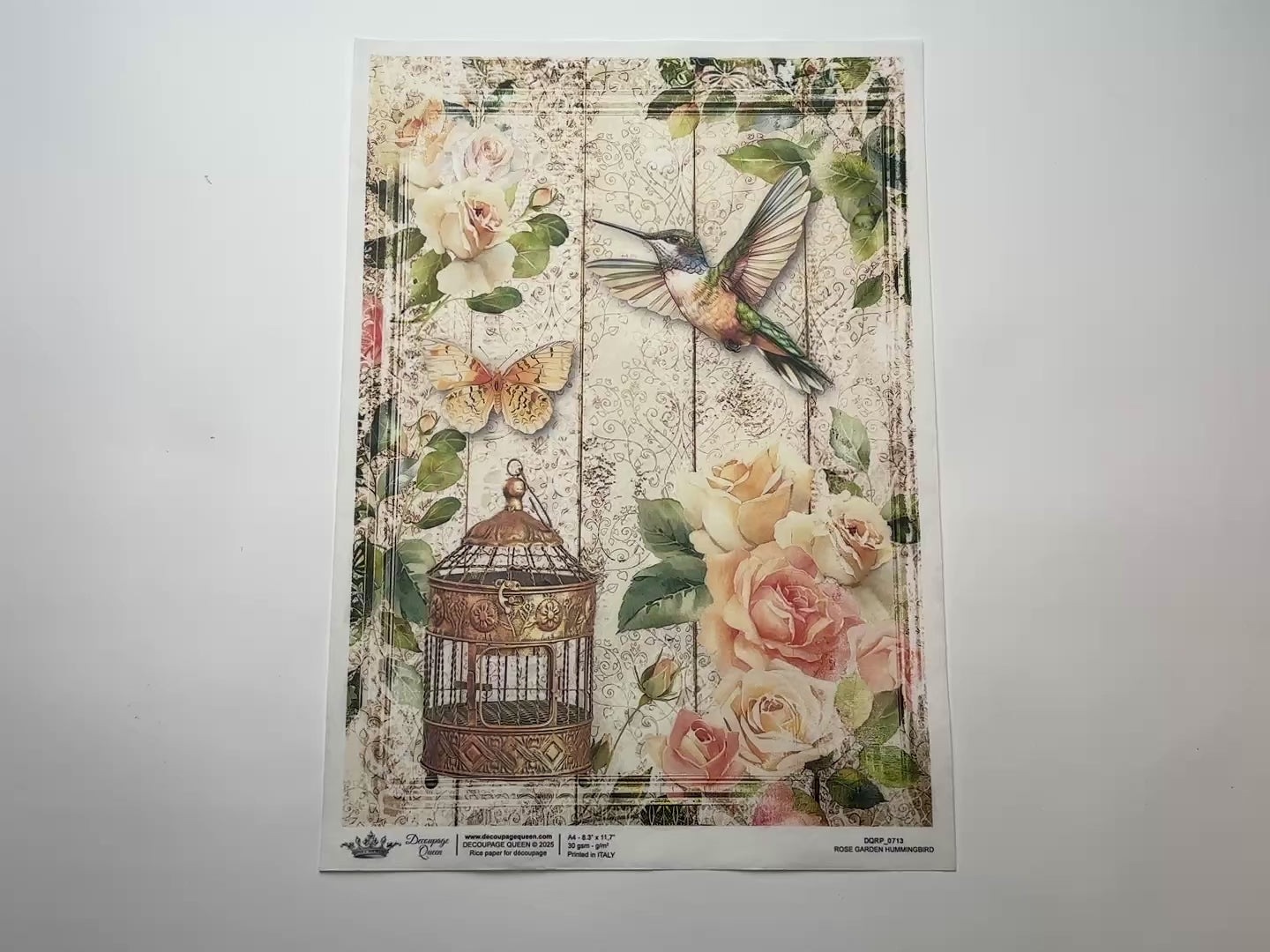 A 14 second video shows a close-up and backside of Decoupage Queen's Rose Garden Hummingbird A4 rice paper against a white background.